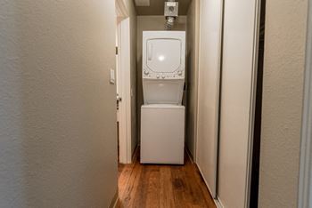 A washer and dryer in a small room with a door